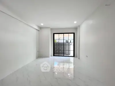 Spacious and bright empty room with large window and glossy floor tiles.
