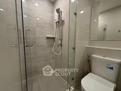 Modern bathroom with glass shower enclosure and sleek fixtures