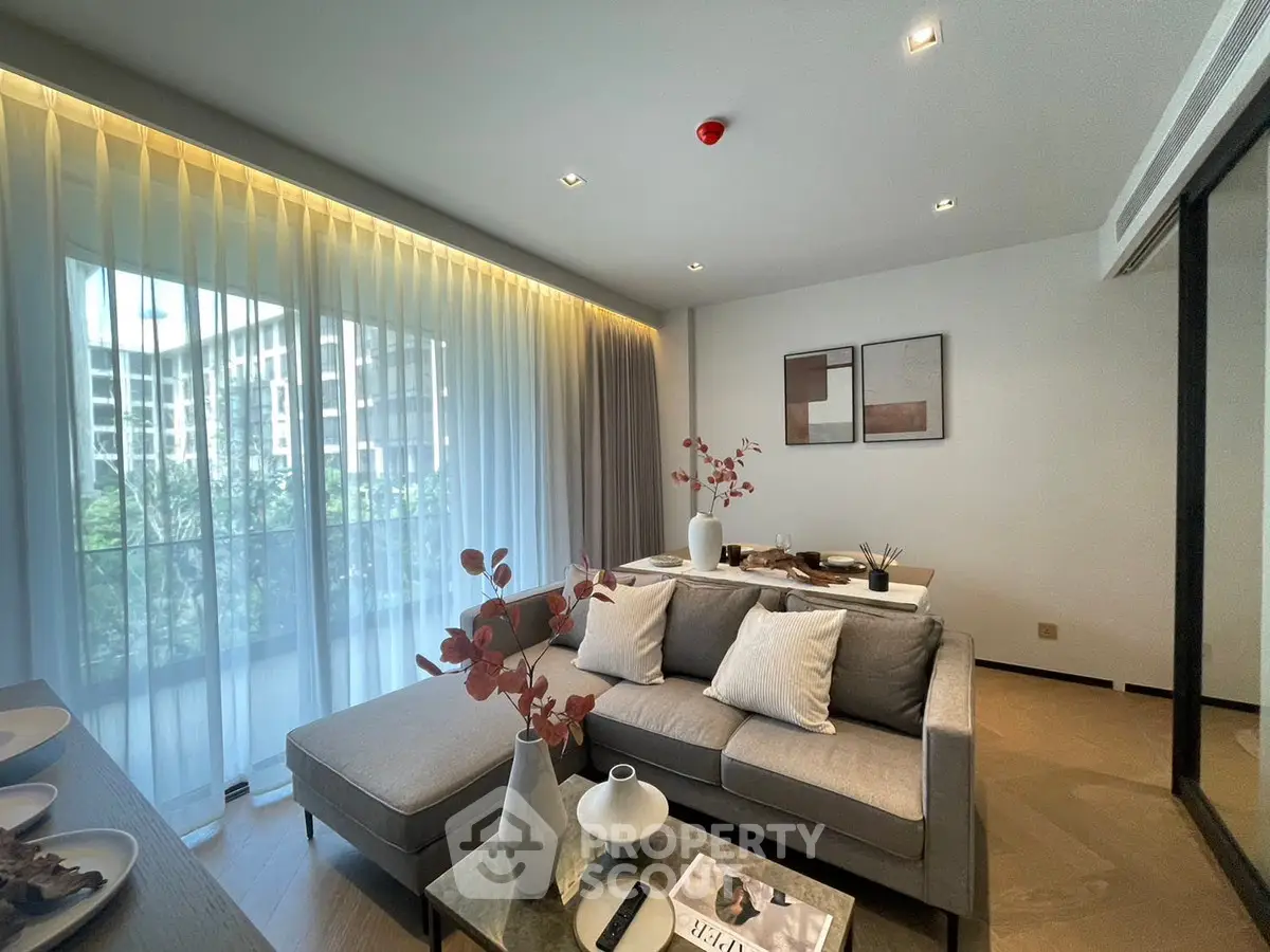 Modern living room with elegant decor and large windows offering natural light.