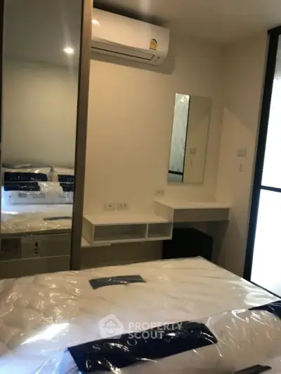 Cozy bedroom with mirrored wardrobe and air conditioning in modern apartment