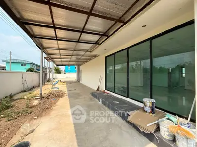 Spacious outdoor patio with large glass doors and covered roof, perfect for relaxation and entertainment.