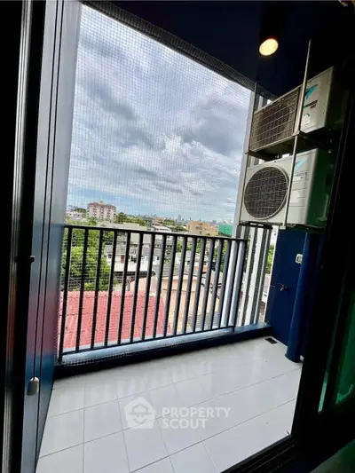 Charming balcony with city view and air conditioning units, perfect for relaxation.