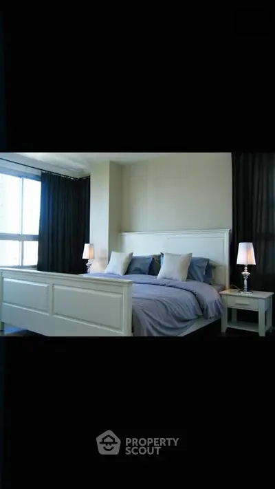 Spacious bedroom with elegant decor and large window for natural light.