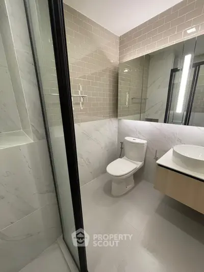 Modern bathroom with sleek design, featuring a glass shower and elegant vanity.