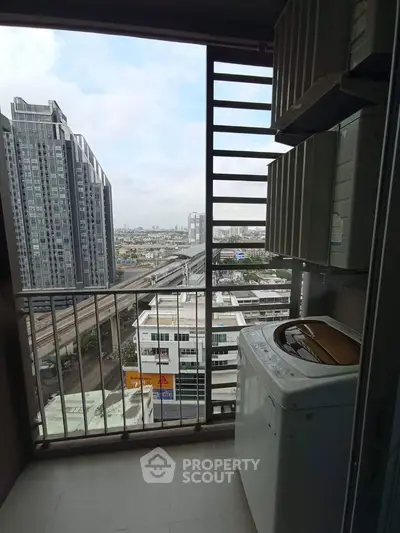 High-rise balcony with city view and washing machine, perfect urban living space.