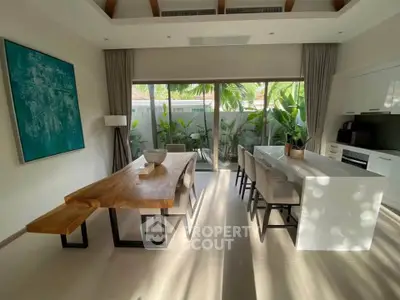Modern open-layout kitchen and dining area with natural light and garden view.