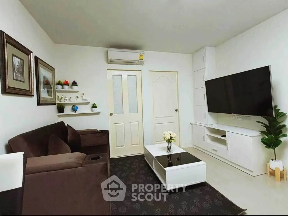 Modern living room with sleek furniture and large TV, perfect for relaxation and entertainment.