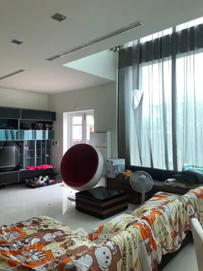 Spacious living room with high ceilings and modern decor, featuring large windows and stylish furniture.