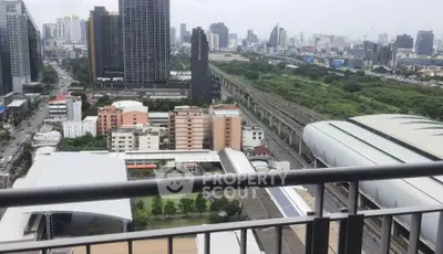 Stunning cityscape view from a high-rise balcony overlooking urban skyline and green spaces.
