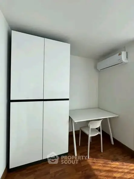 Modern study nook with sleek white furniture and air conditioning in a compact space.