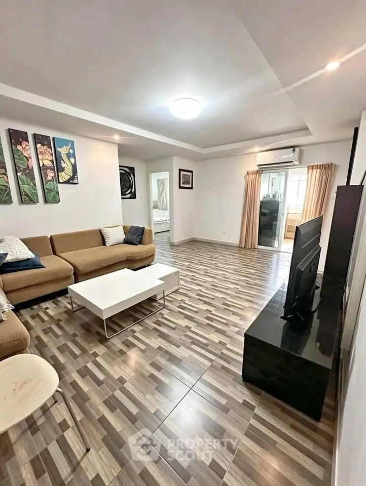 Spacious living room with modern decor and stylish flooring, perfect for relaxation and entertainment.