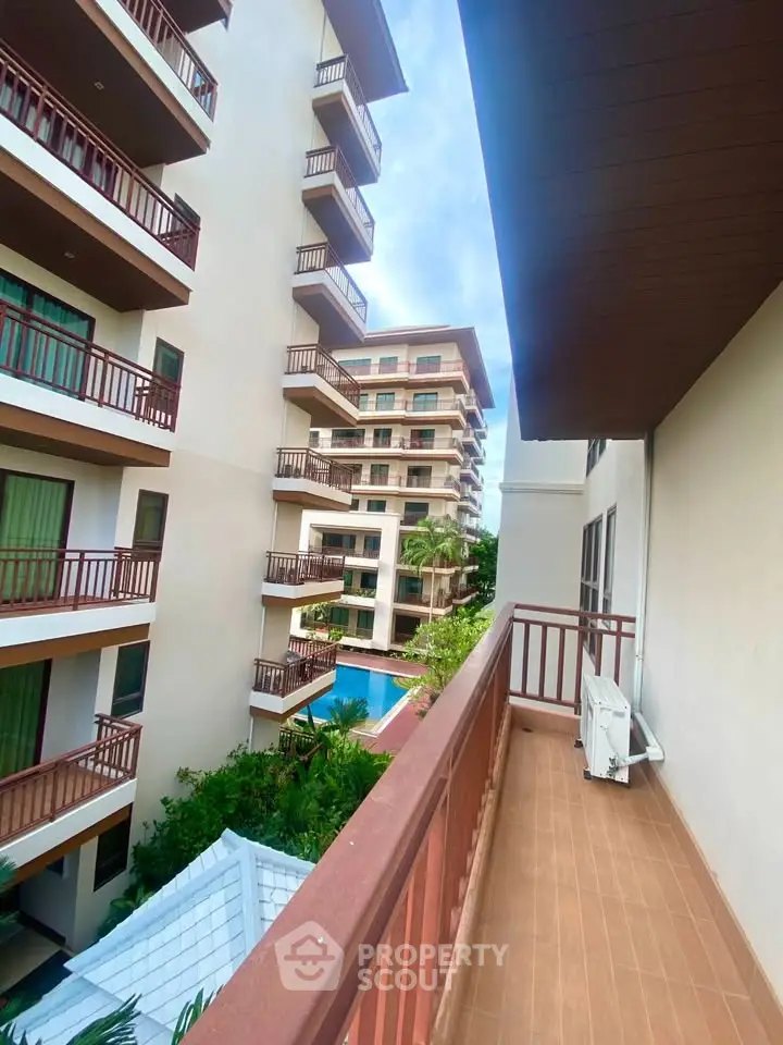 Spacious balcony with pool view in modern apartment complex