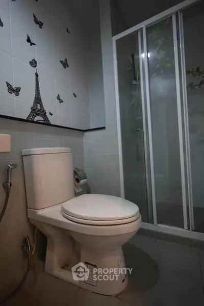 Modern bathroom with shower and elegant wall decor featuring Eiffel Tower and butterflies.
