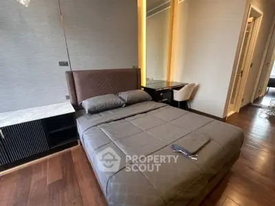 Modern bedroom with stylish decor and wooden flooring, featuring a cozy bed and elegant furnishings.