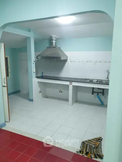 Spacious kitchen with open layout and modern ventilation system.