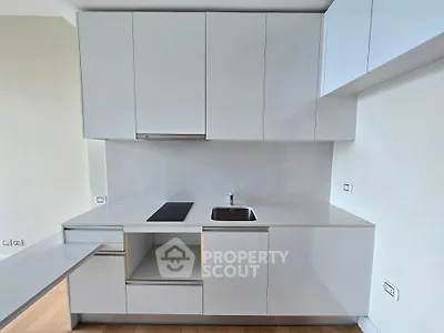 Modern minimalist kitchen with sleek white cabinetry and integrated appliances.