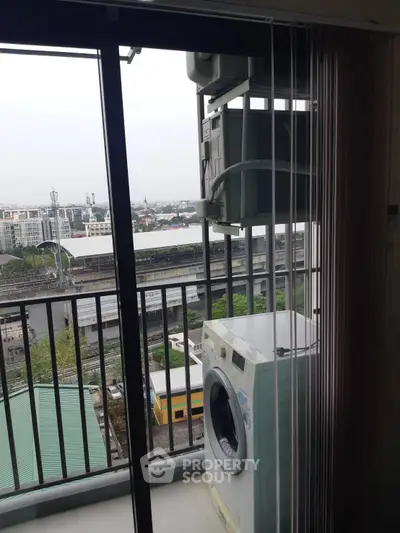 High-rise apartment balcony with washing machine and city view