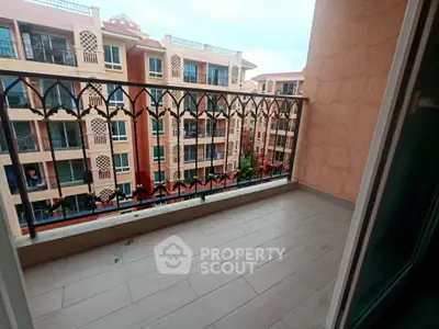 Charming balcony with intricate railing offering a view of Mediterranean-style architecture.