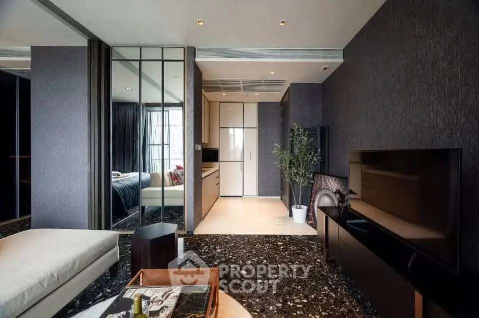 Modern living room with sleek design, mirrored walls, and open kitchen layout in luxury apartment.