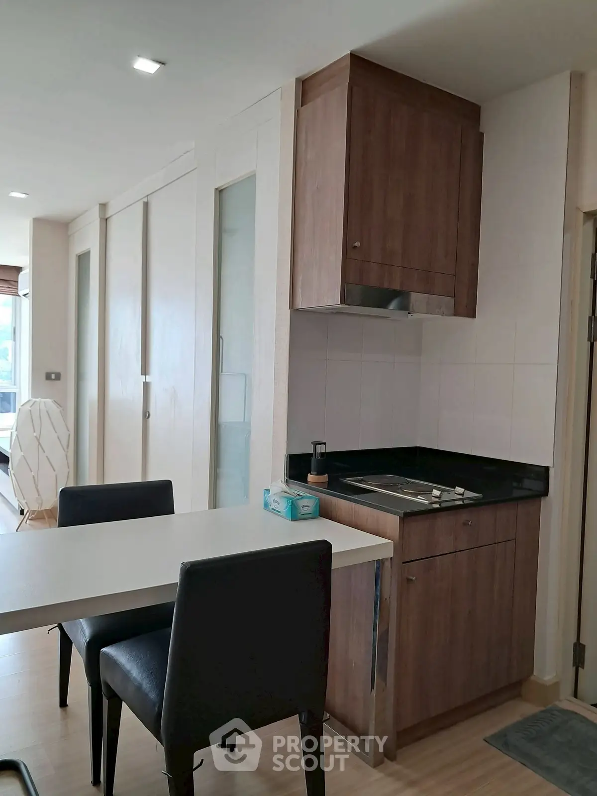 Modern kitchen with sleek cabinetry and dining area in a stylish apartment.