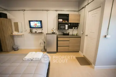 Modern studio apartment with kitchenette and cozy bed