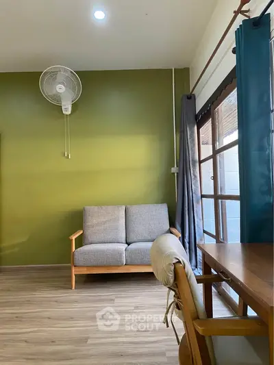 Cozy living room with green accent wall and natural light