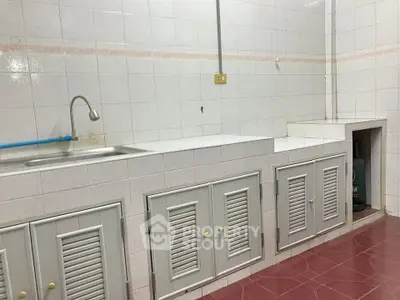Spacious kitchen with tiled walls and ample storage cabinets