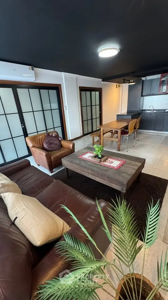 Stylish open-layout living room with modern kitchen and cozy seating area.