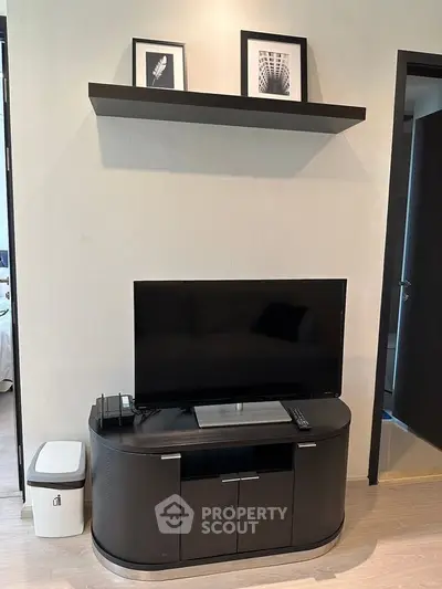 Modern living room with sleek TV stand and wall shelf, showcasing minimalist interior design.