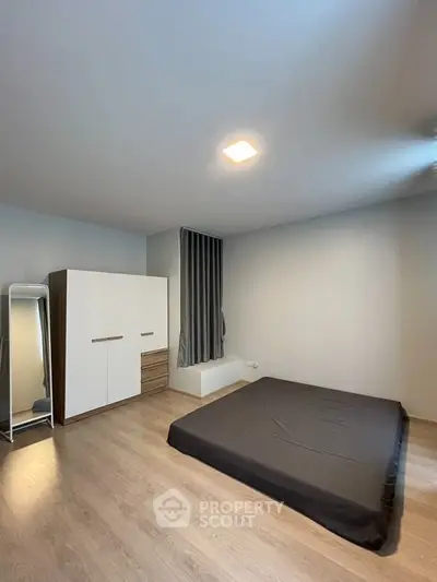Minimalist bedroom with wooden flooring and modern wardrobe