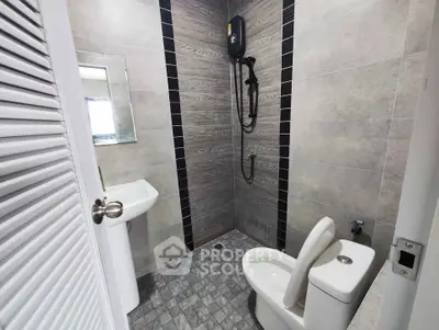Modern bathroom with sleek shower and contemporary fixtures in a stylish real estate property.