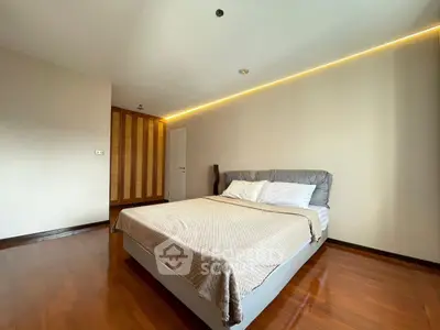 Spacious bedroom with modern design and wooden flooring