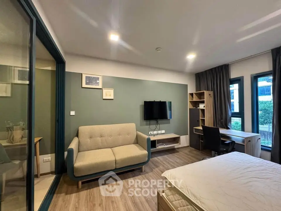 Modern studio apartment with cozy living area and study desk, featuring stylish decor and ample natural light.
