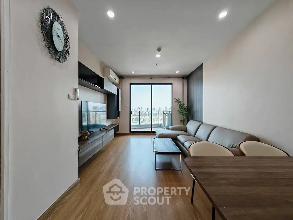 Spacious modern living room with city view, elegant decor, and natural light.