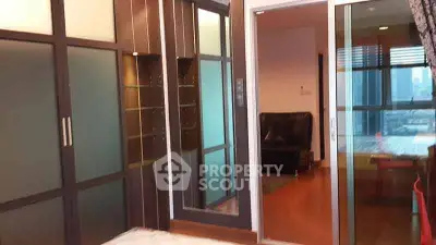 Modern apartment interior with sliding glass doors and city view, featuring stylish decor and spacious layout.