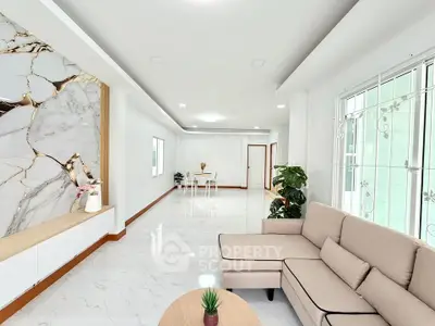 Spacious modern living room with elegant marble accents and cozy seating area.