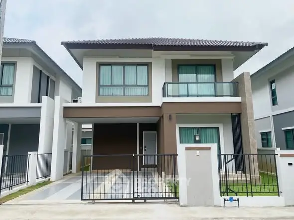 Modern two-story house with sleek design and gated driveway in suburban neighborhood.
