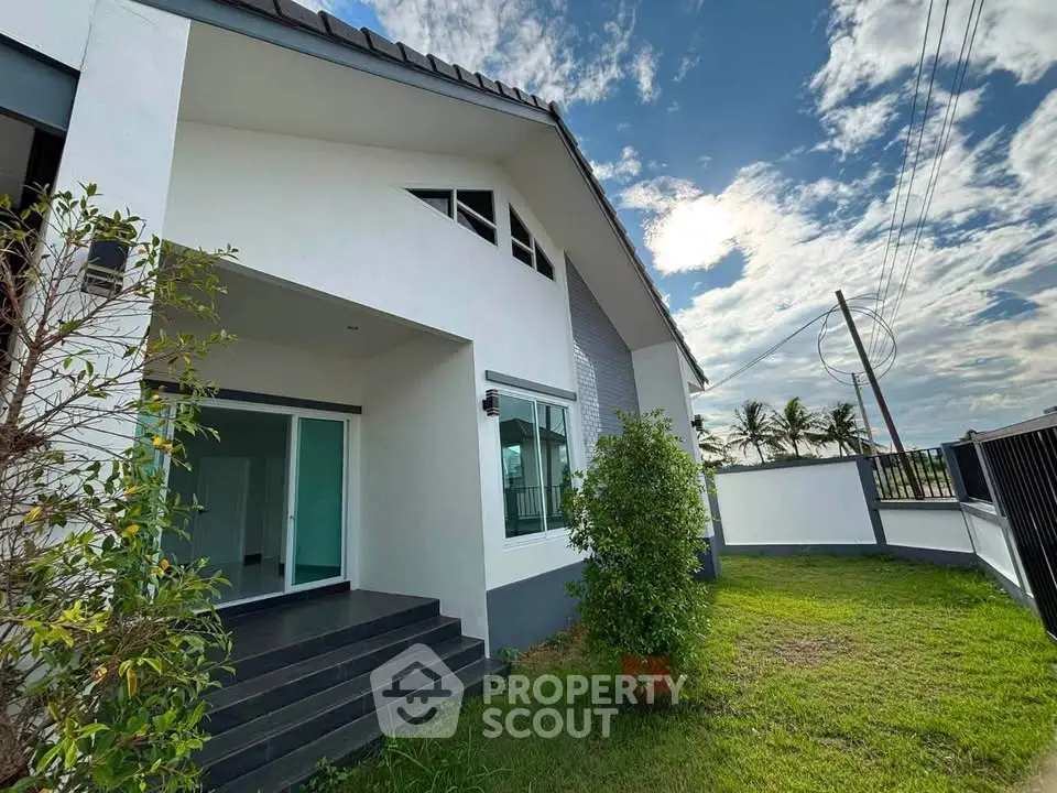 Charming modern house exterior with lush green lawn and spacious entrance, perfect for family living.