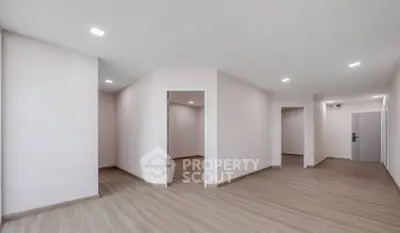 Spacious modern apartment interior with sleek wooden flooring and minimalist design.