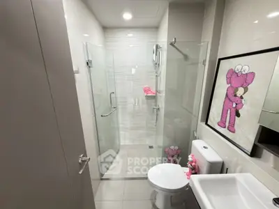 Modern bathroom with glass shower and unique pink decor accents