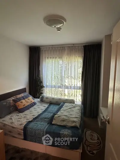 Cozy bedroom with large window and elegant curtains, perfect for relaxation and comfort.