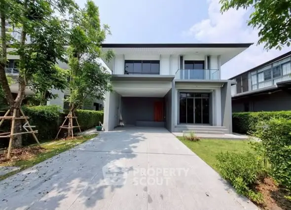 Modern two-story house with driveway and lush greenery