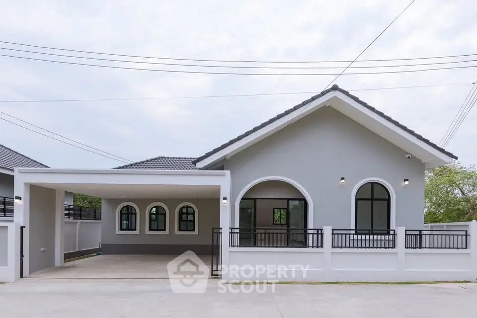 Modern single-story house with arched windows and spacious driveway