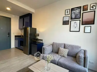 Modern living room with stylish decor and compact kitchen in open layout apartment.