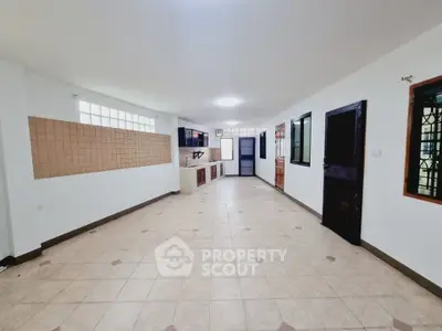 Spacious open-plan living area with tiled flooring and modern kitchen.