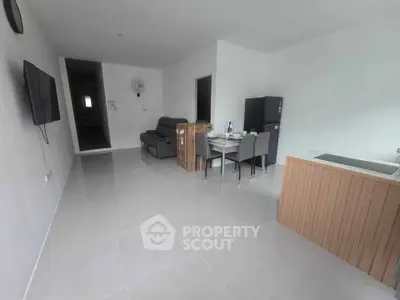 Spacious modern living room with sleek furniture and open kitchen layout.