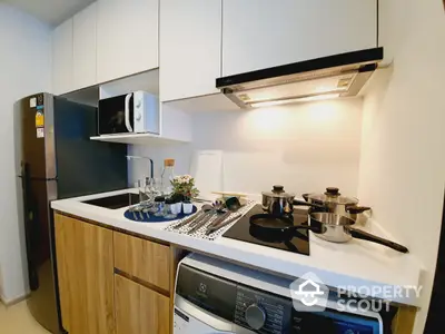 Compact modern kitchen with white cabinetry, built-in appliances, and wooden accents, perfect for urban living.