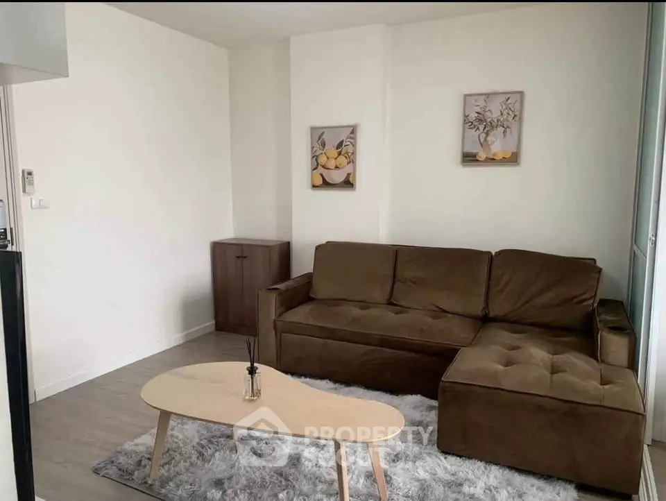 Cozy living room with brown sofa, modern decor, and stylish coffee table on plush rug.