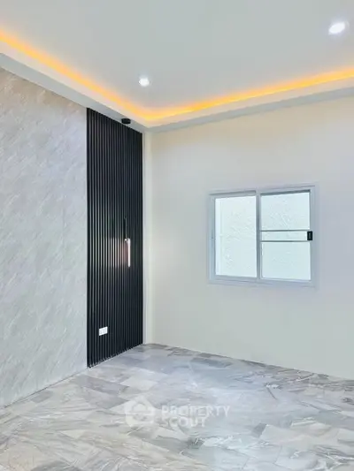 Modern minimalist room with sleek lighting and textured walls, perfect for stylish living.