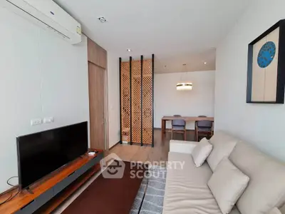 Modern living room with stylish decor and open layout, featuring a cozy sofa and wall-mounted TV.